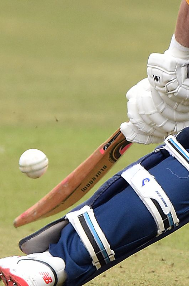 Close up of cricket ball and bat as a player is hitting the ball