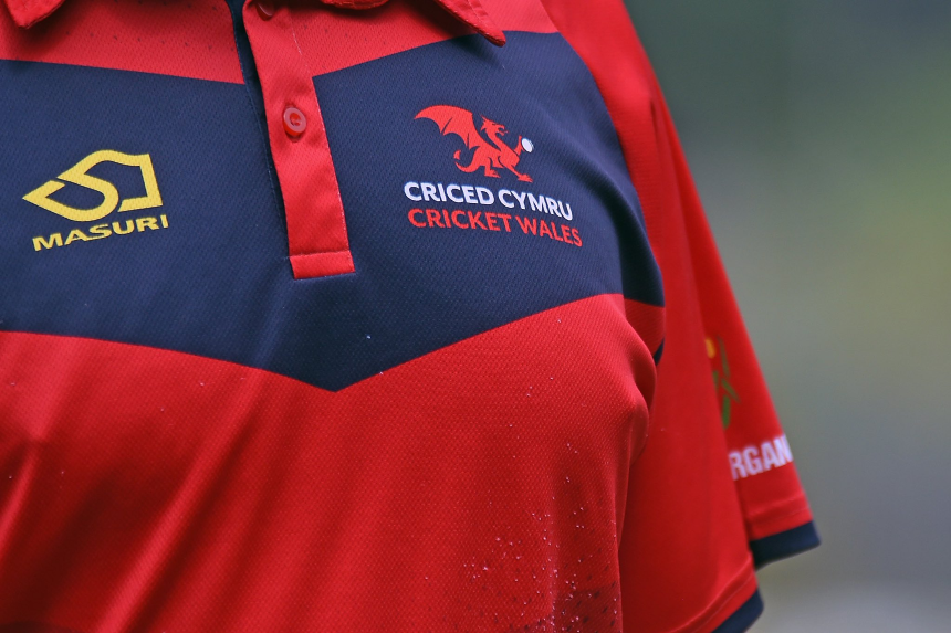 Close up of Cricket Wales crest on a red and navy sports shirt