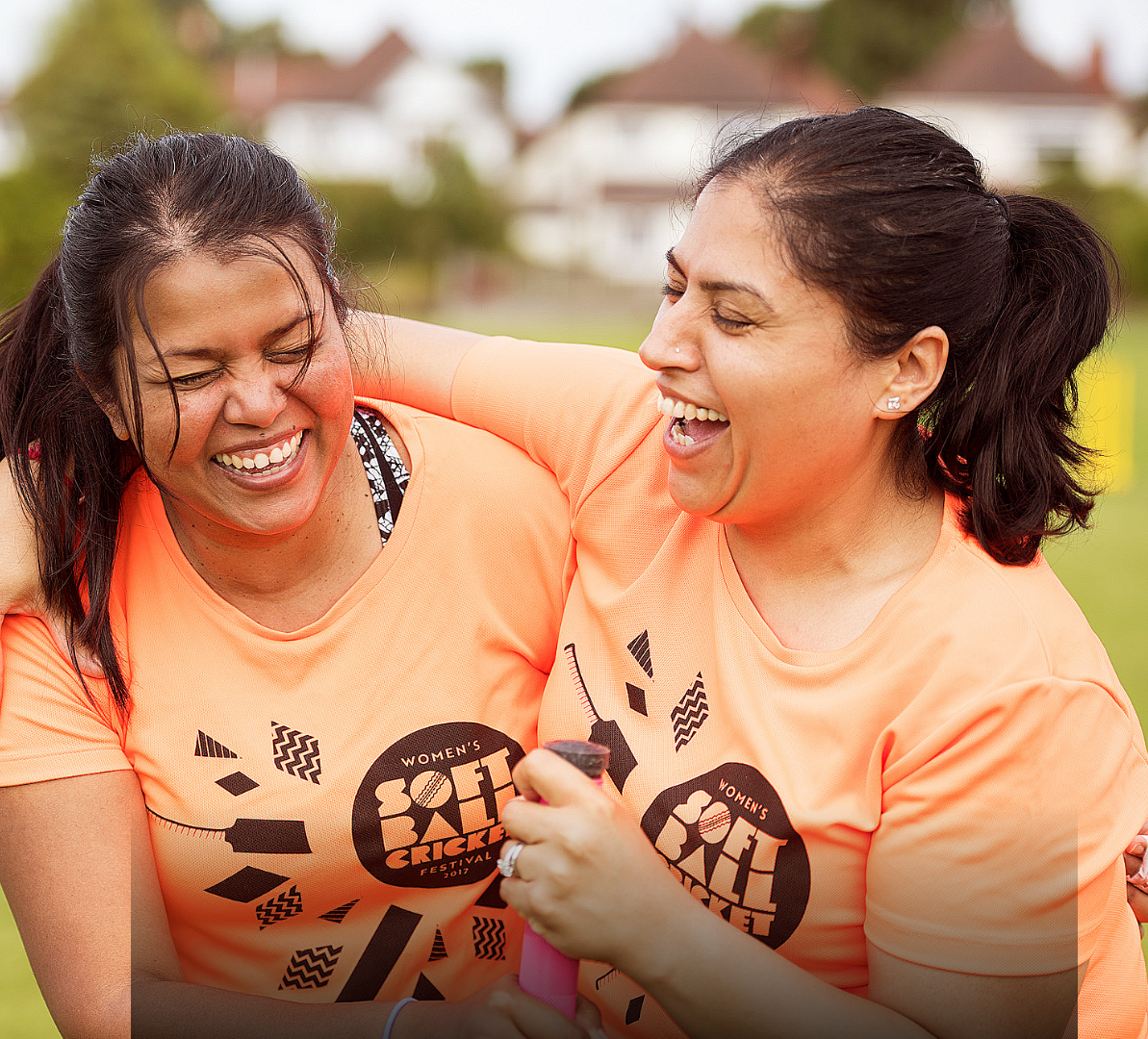 Two women laughing in Women's Soft Ball Cricket t-shirts