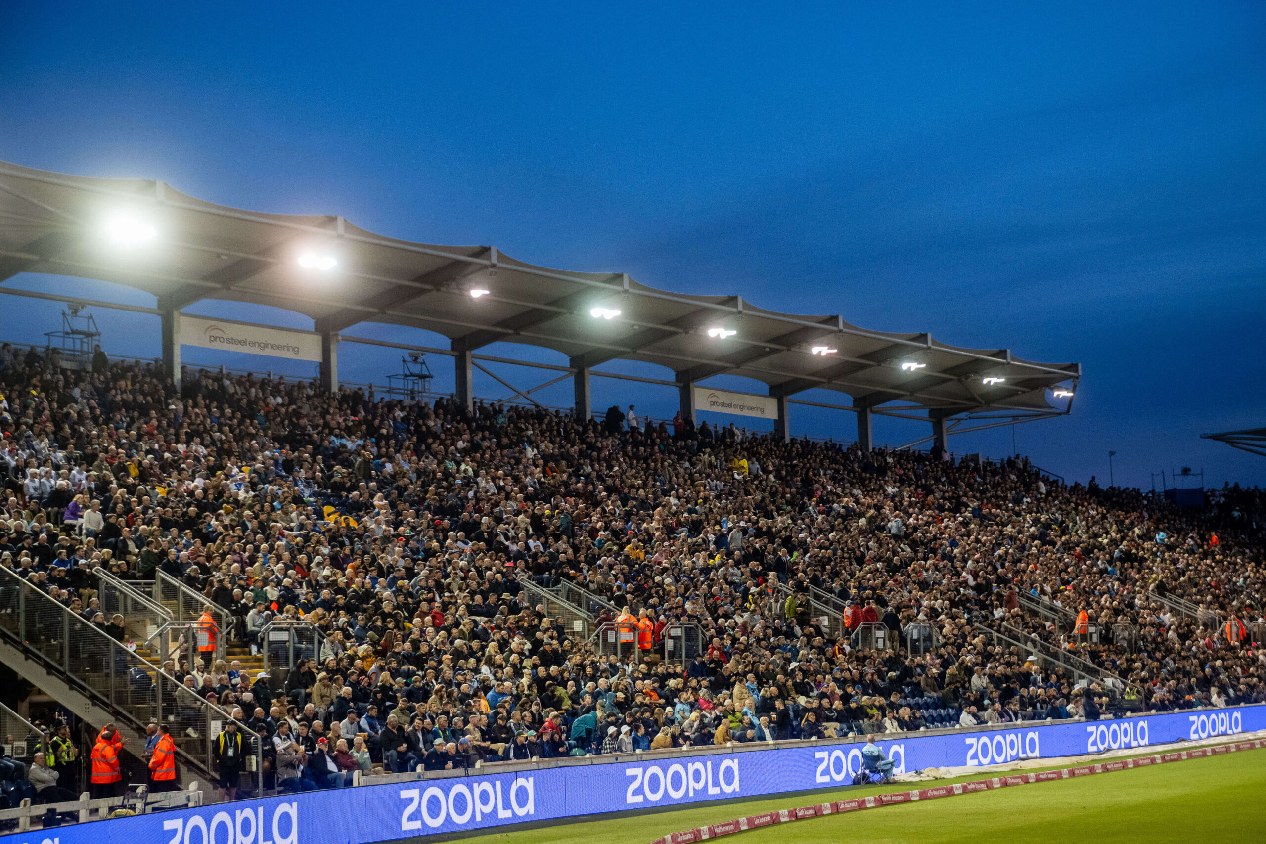 Night time image of Sophia Gardens Cricket grounds with packed stands and lights on pitch